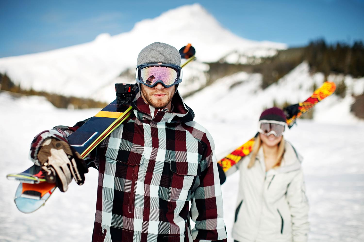 Un couple avec les skis sur l'épaules