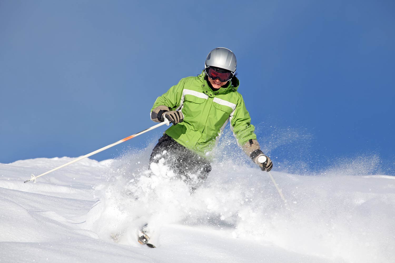 Une femme descend une piste de ski en poudreuse